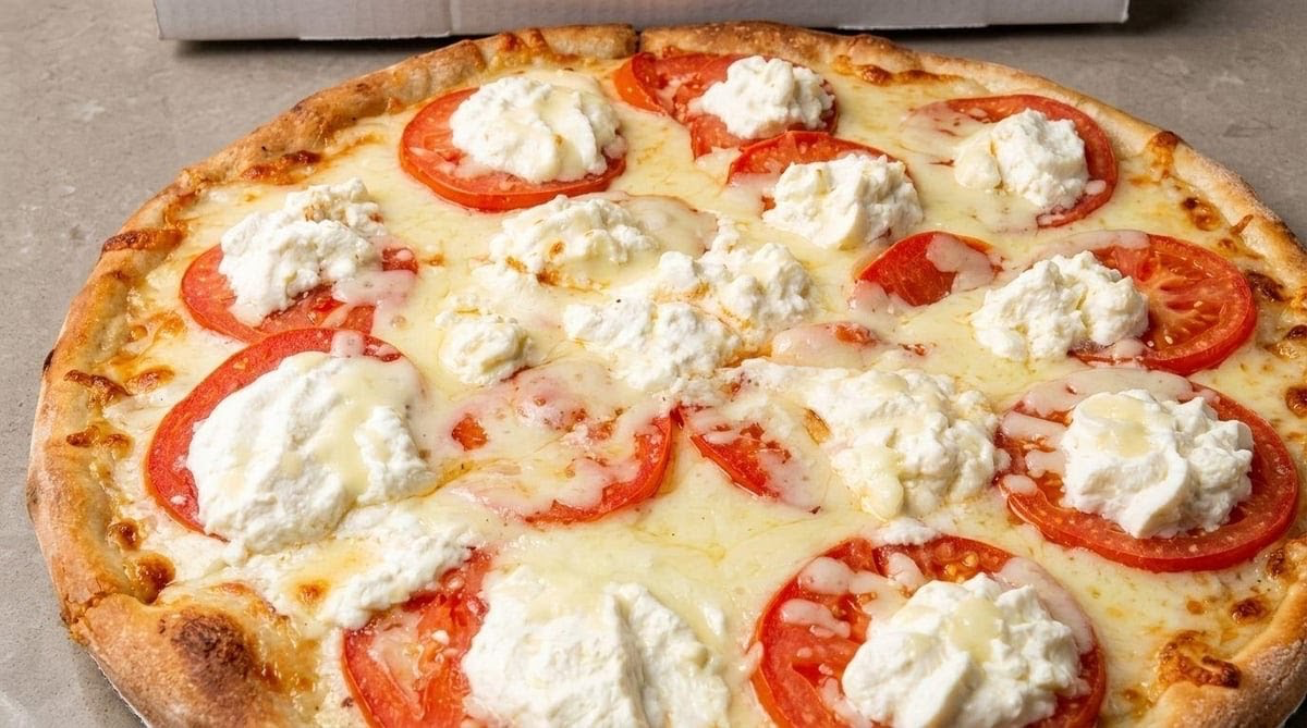 Pizza topped with fresh tomatoes and ricotta